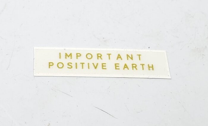 Triumph "Important Positive Earth" Decal - Gold - 1-7/8" x 5/8"